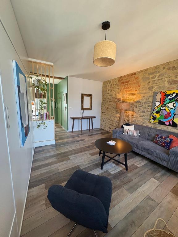 Le studio pilote à Vannes — séjour avec mur en pierres apparentes